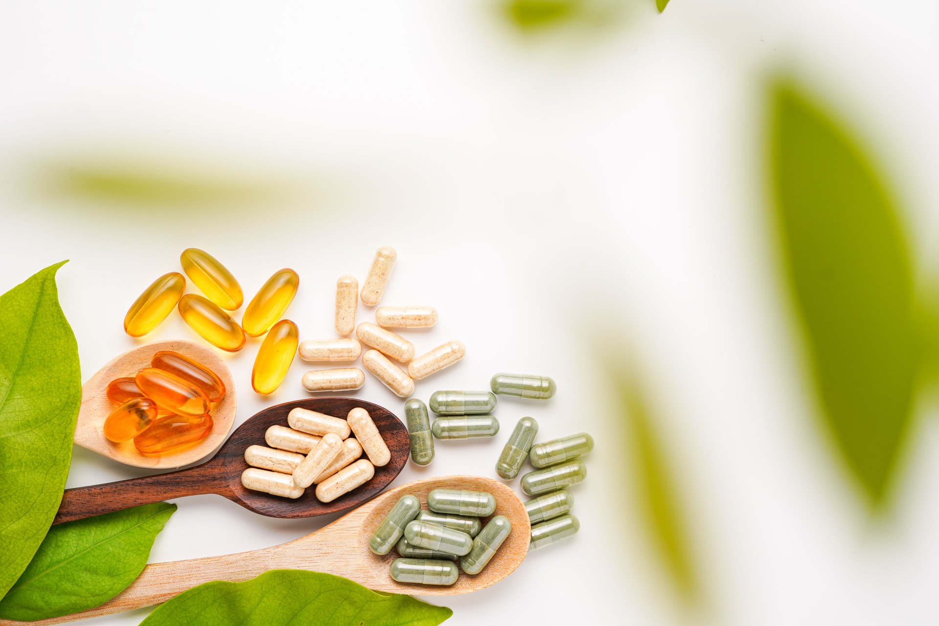Vitamin capsules in a wooden spoon, soft gels, Fish oil capsules, omega 3, omega 9, vitamin D, vitamin E